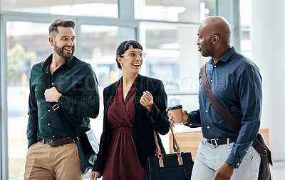 Buy stock photo Cropped shot of three business colleagues talking while walking through their office