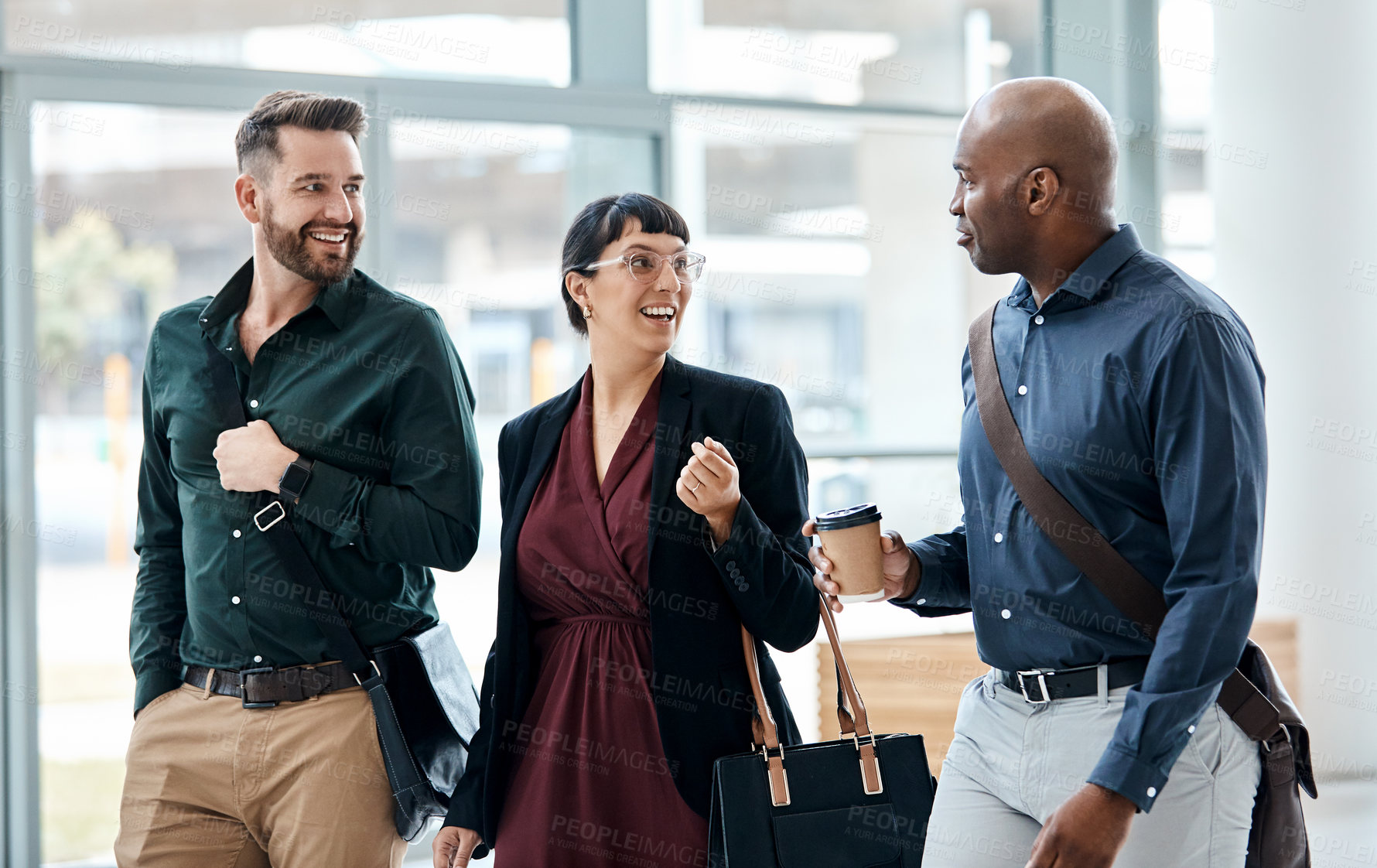 Buy stock photo Cropped shot of three business colleagues talking while walking through their office