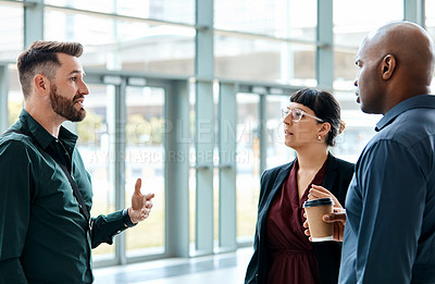 Buy stock photo Cropped shot of three business colleagues talking while standing in their office