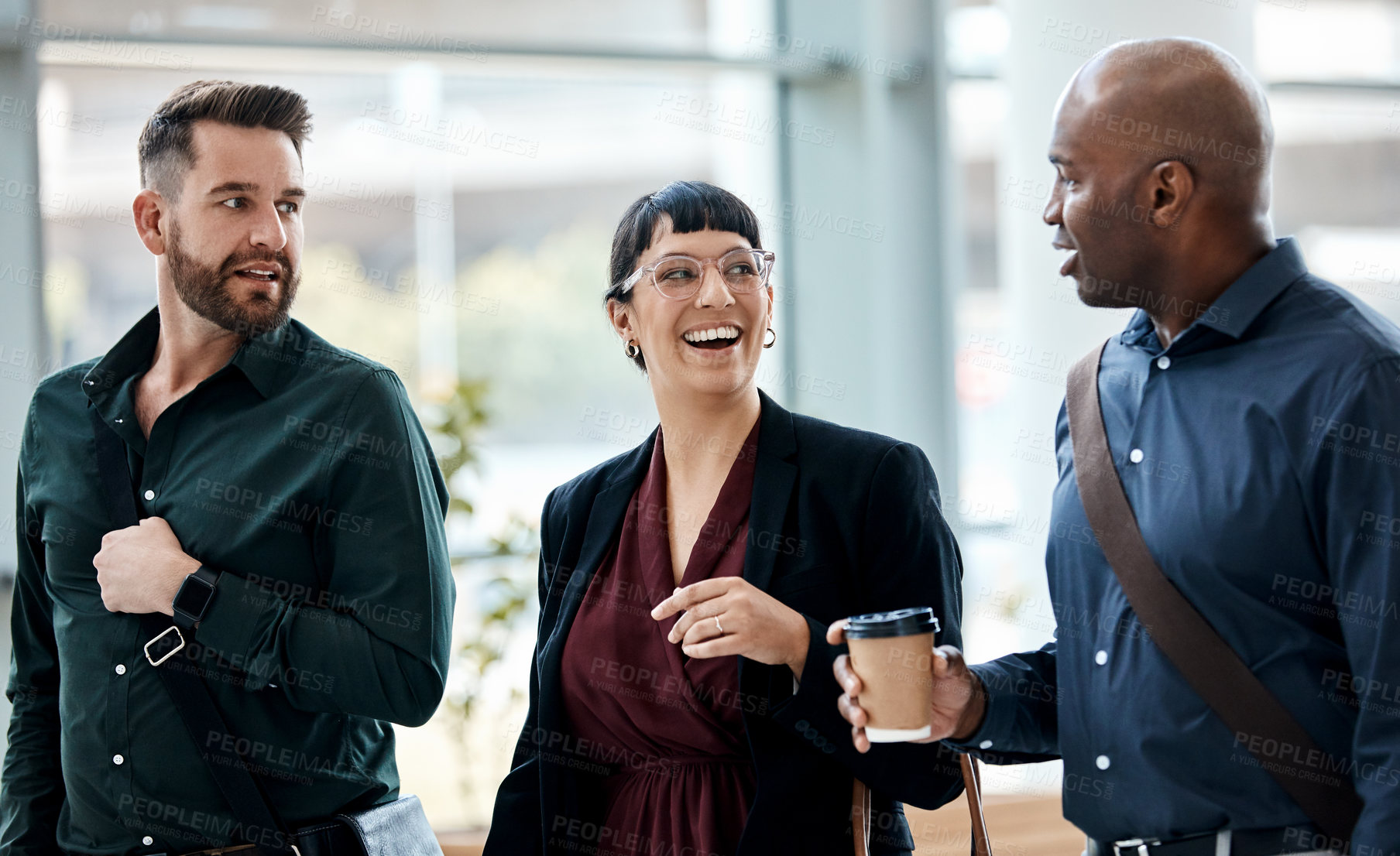 Buy stock photo Cropped shot of three business colleagues talking while walking through their office
