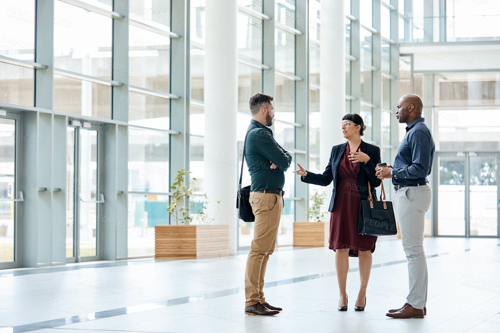 Buy stock photo Full length shot of three business colleagues talking while standing in their office