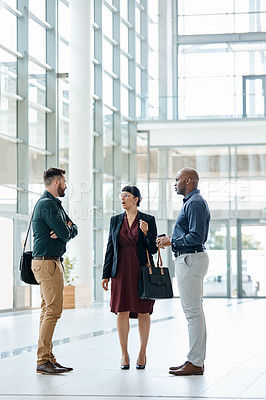 Buy stock photo Full length shot of three business colleagues talking while standing in their office