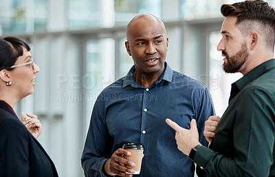 Buy stock photo Cropped shot of three business colleagues talking while standing in their office