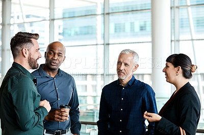 Buy stock photo Cropped shot of four business colleagues talking while standing in their office