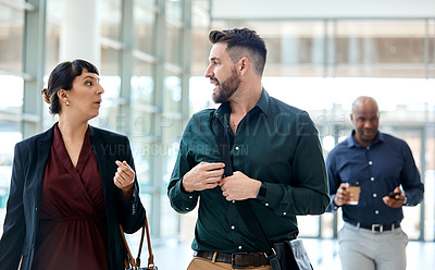 Buy stock photo Cropped shot of two business colleagues talking while walking through their office