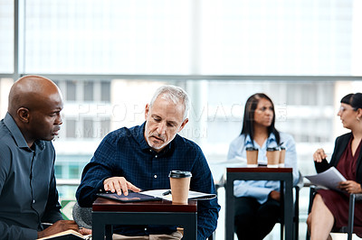 Buy stock photo Cropped shot of two businessmen having in discussion in the office with their colleagues in the background