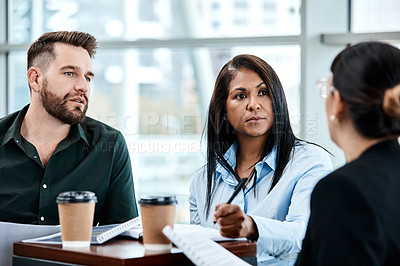 Buy stock photo Cropped shot of three business colleagues having a discussion while sitting in their office