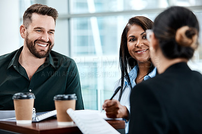 Buy stock photo Cropped shot of three business colleagues having a discussion while sitting in their office