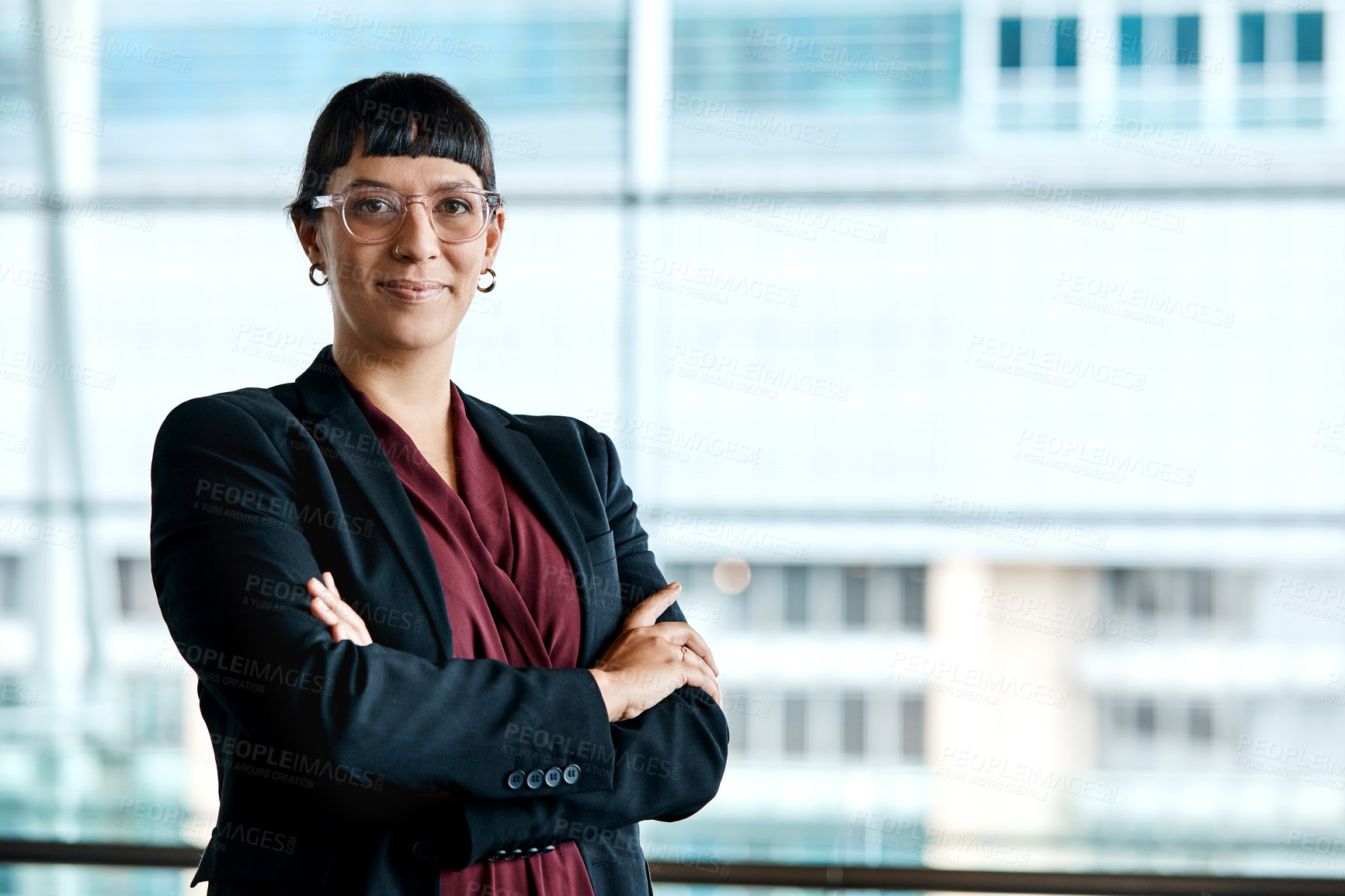 Buy stock photo Cropped portrait of an attractive businesswoman standing with her arms folded in the office