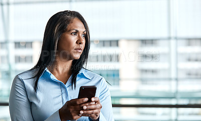 Buy stock photo Cropped shot of an attractive businesswoman texting while standing in her office