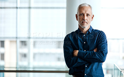 Buy stock photo Cropped portrait of a handsome businessman standing with his arms folded in the office