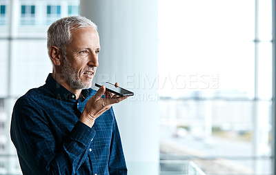 Buy stock photo Cropped shot of a handsome businessman making a phonecall while standing in his office
