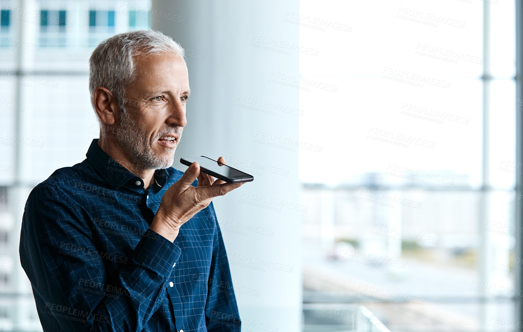Buy stock photo Cropped shot of a handsome businessman making a phonecall while standing in his office