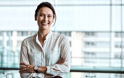 Buy stock photo Cropped portrait of an attractive businesswoman standing with her arms folded in the office