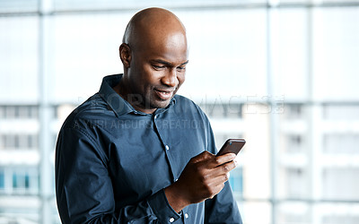 Buy stock photo Cropped shot of a handsome businessman texting while standing in his office