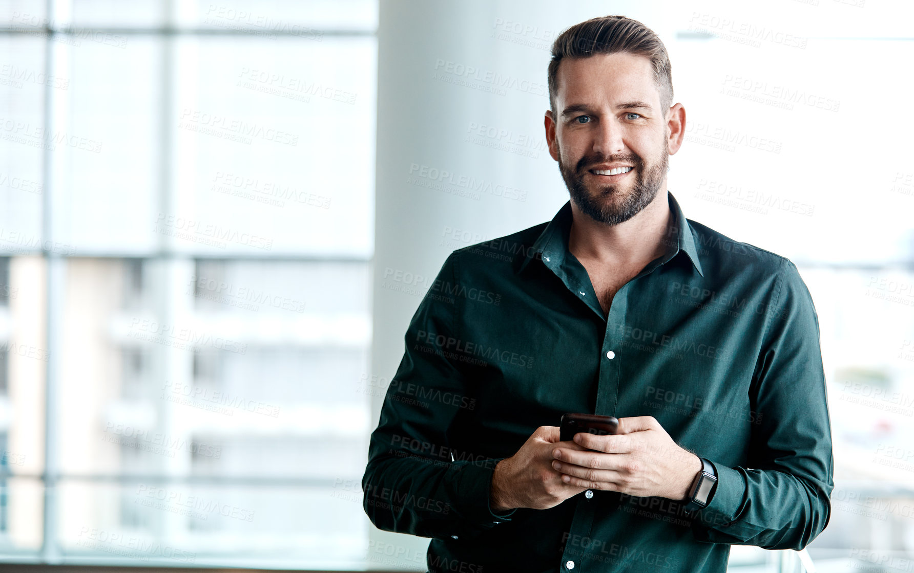 Buy stock photo Cropped portrait of a handsome businessman texting while standing in his office