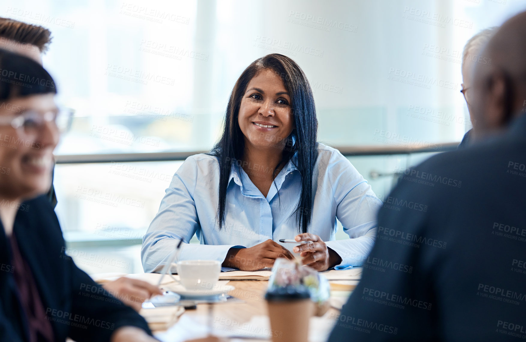 Buy stock photo Shot of a mature businesswoman taking down notes during a meeting with colleagues at work