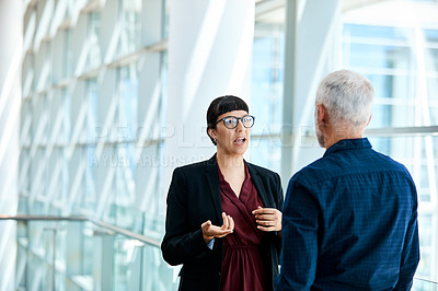 Buy stock photo Shot of a young businesswoman having a discussion with a senior staff member at work