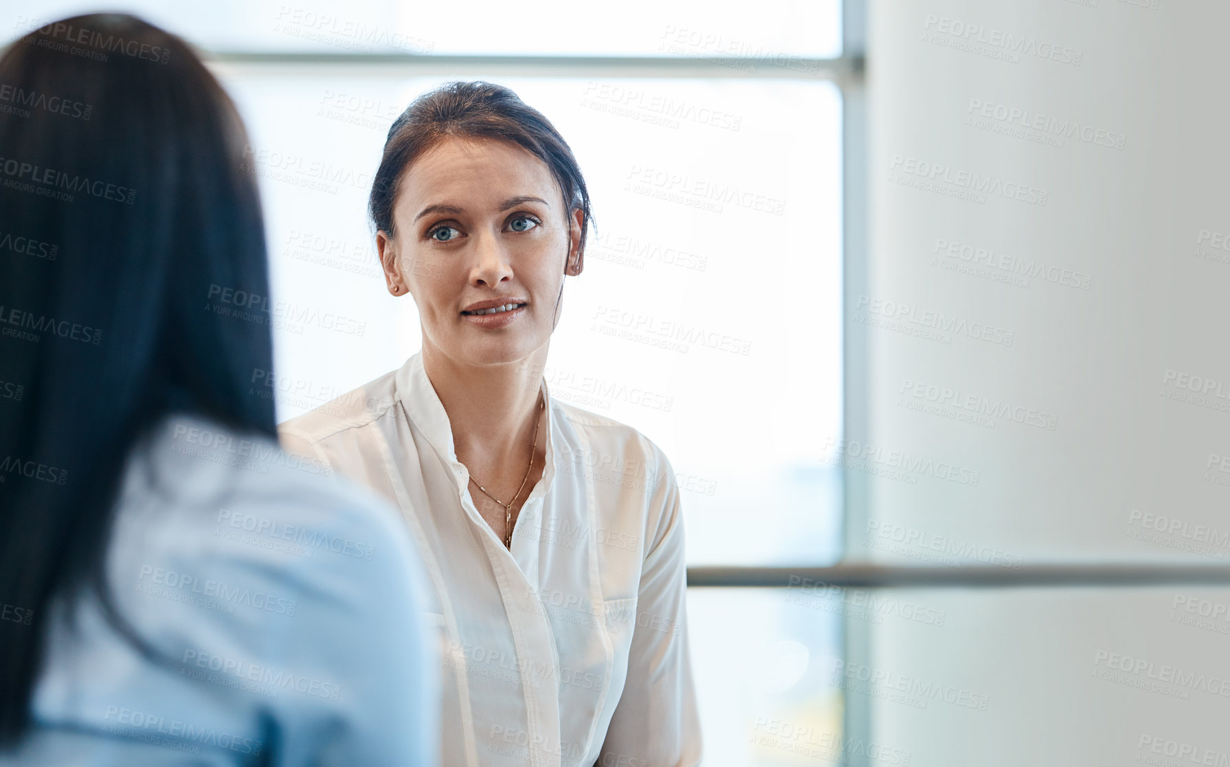 Buy stock photo Shot of two businesspeople people having a conversation together during a meeting with colleagues at work