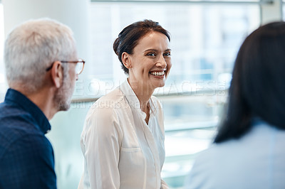 Buy stock photo Shot of an attractive businesswoman smiling during a meeting with colleagues at work