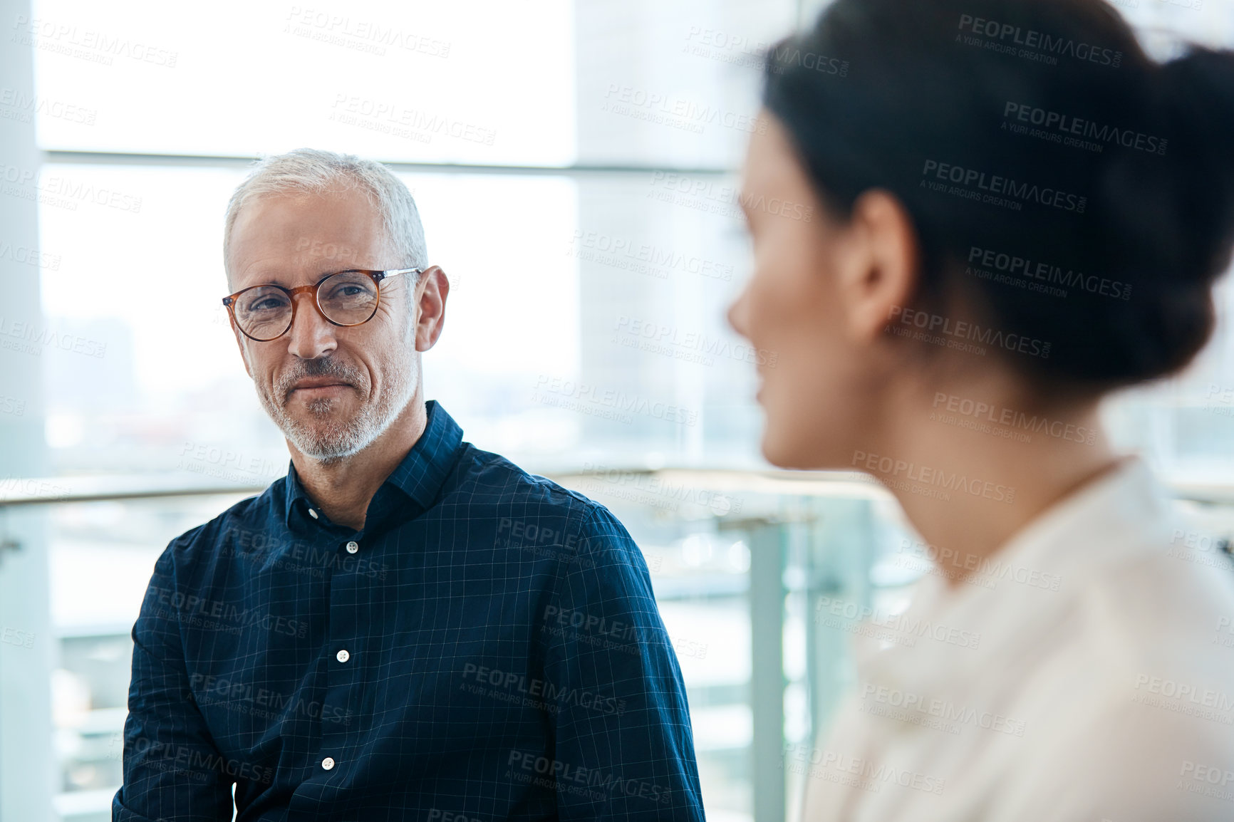 Buy stock photo Shot of a mature businessman listening attentively during a meeting with colleagues at work