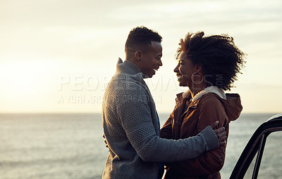 Buy stock photo Cropped shot of an affectionate young couple holding each other while standing on the beach during a road trip