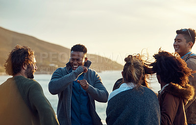 Buy stock photo Cropped shot of a diverse group of young friends standing together and dancing on the beach during a road trip