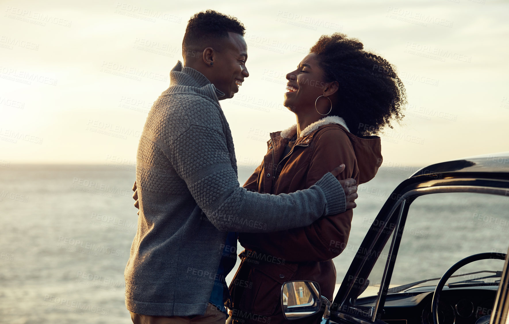 Buy stock photo Cropped shot of an affectionate young couple holding each other while standing on the beach during a road trip