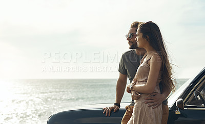 Buy stock photo Cropped shot of an affectionate young couple standing close to each other and leaning on a car by the ocean