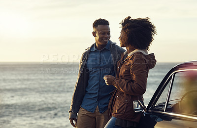 Buy stock photo Cropped shot of an affectionate young couple standing closely together and leaning on a car while by the ocean