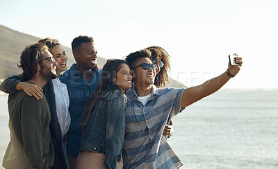 Buy stock photo Cropped shot of a diverse young group of friends posing for a selfie together while on the beach