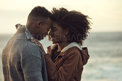 Buy stock photo Cropped shot of an affectionate young couple holding each other while outside at the beach during a road trip