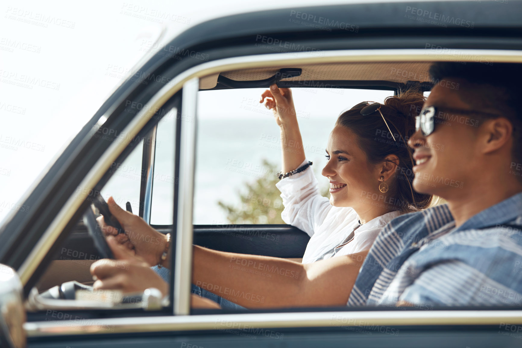 Buy stock photo Happy, woman and couple in car for road trip, adventure and bonding together on holiday journey. Smile, people and scenic drive in vehicle for travel, outdoor view and weekend getaway on vacation