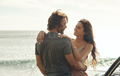 Buy stock photo Cropped shot of an affectionate young couple holding each other and standing together on the beach during a road trip