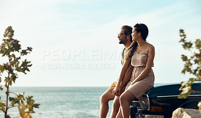 Buy stock photo Cropped shot of an affectionate young couple holding hands while sitting on a car at the beach during a road trip