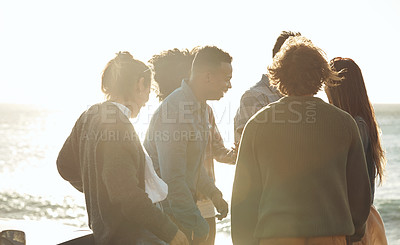 Buy stock photo Rearview shot of a diverse group of young friends socialising at the beach during a road trip