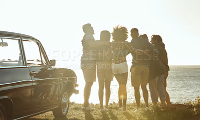 Buy stock photo Full length rearview shot of a diverse young group of friends standing next to a car and facing the ocean
