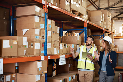 Buy stock photo Cropped shot of an attractive young businesswoman walking through a warehouse with a male worker