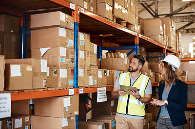 Buy stock photo Cropped shot of an attractive young businesswoman walking through a warehouse with a male worker