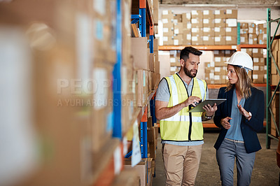 Buy stock photo Cropped shot of an attractive young businesswoman walking through a warehouse with a male worker