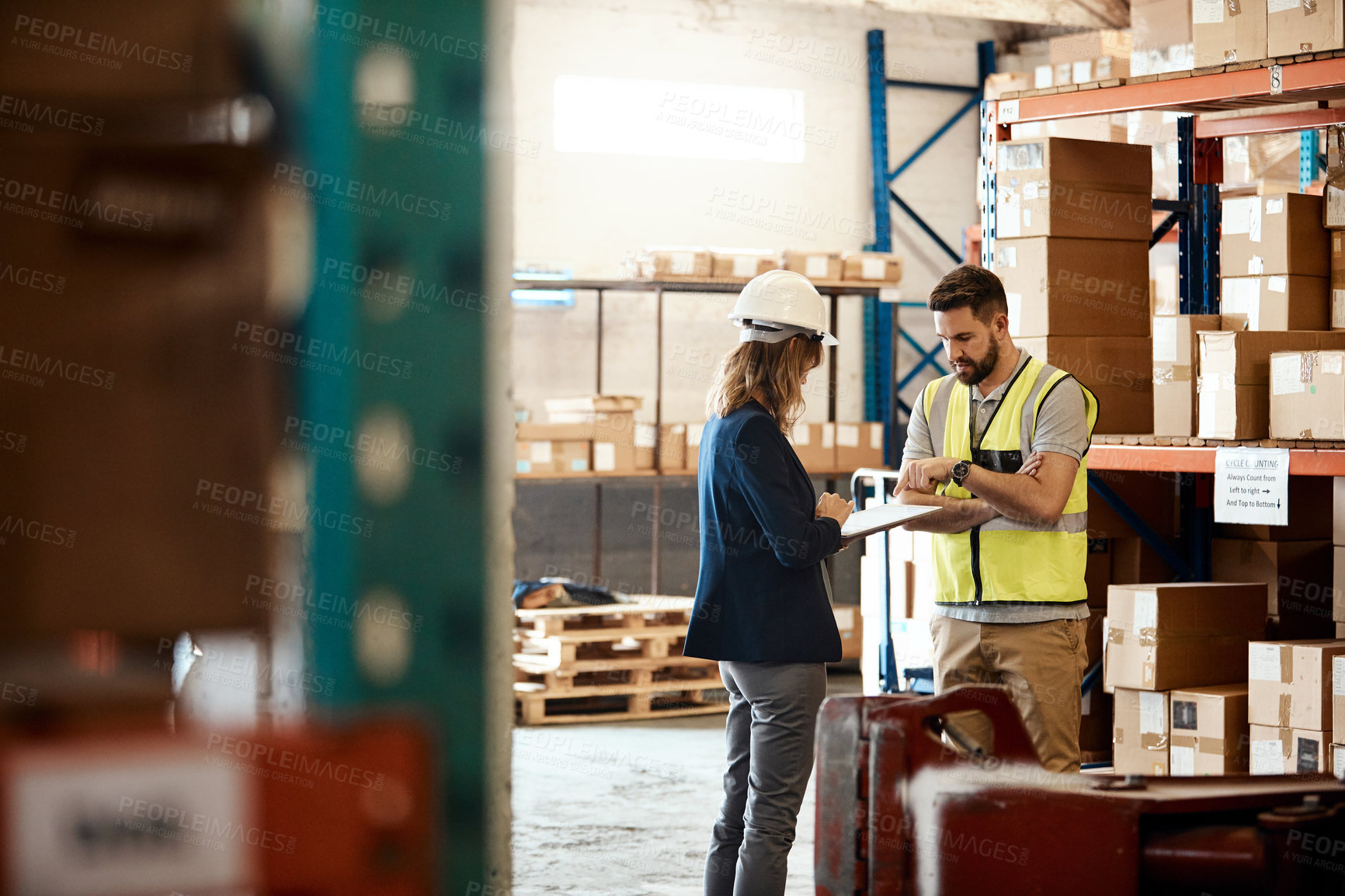 Buy stock photo Cropped shot of a handsome young male warehouse worker talking to his supervisor