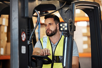 Buy stock photo Cropped shot of a handsome young male warehouse worker driving a forklift