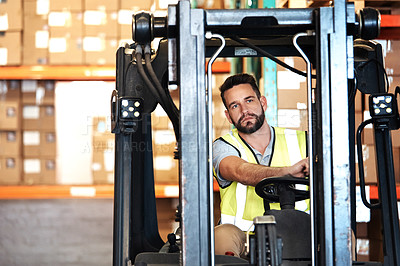 Buy stock photo Cropped shot of a handsome young male warehouse worker driving a forklift