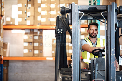 Buy stock photo Cropped shot of a handsome young male warehouse worker driving a forklift