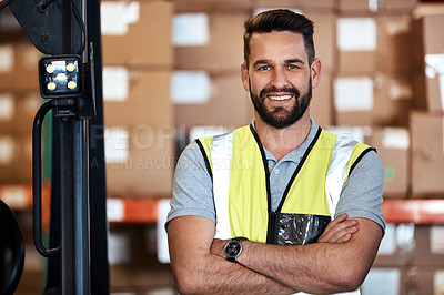 Buy stock photo Cropped portrait of a handsome young male warehouse worker standing with his arms crossed