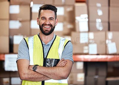 Buy stock photo Cropped portrait of a handsome young male warehouse worker standing with his arms crossed