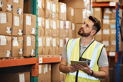 Buy stock photo Cropped shot of a handsome young male warehouse worker checking stock