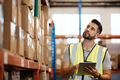 Buy stock photo Cropped shot of a handsome young male warehouse worker checking stock