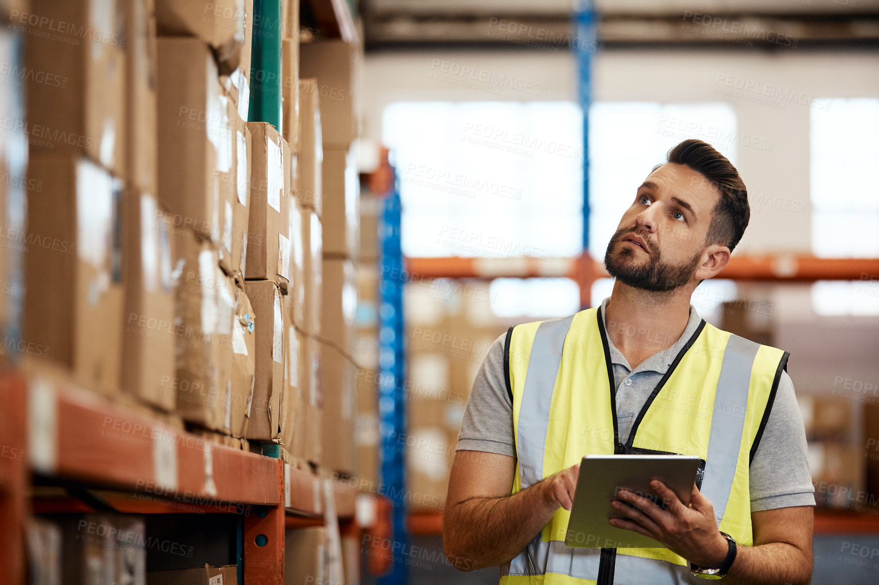Buy stock photo Cropped shot of a handsome young male warehouse worker checking stock