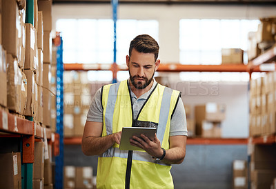 Buy stock photo Cropped shot of a handsome young male warehouse worker checking stock